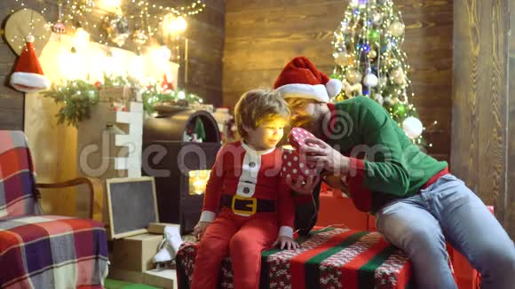 圣诞老人祝儿子圣诞快乐带圣诞礼盒的快乐孩子圣诞老人礼物视频的预览图