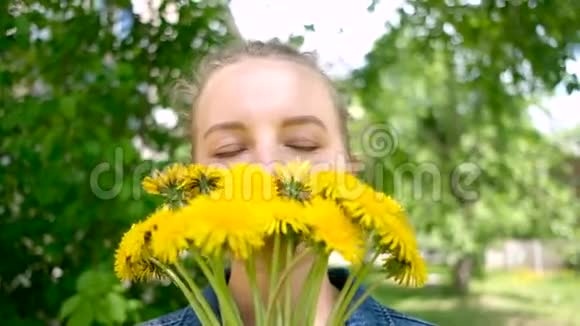 微笑的女人捧着花束的蒲公英女人和黄色野花视频的预览图