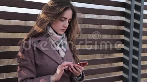 年轻女孩在她的手机里找东西在公园里心烦意乱视频的预览图