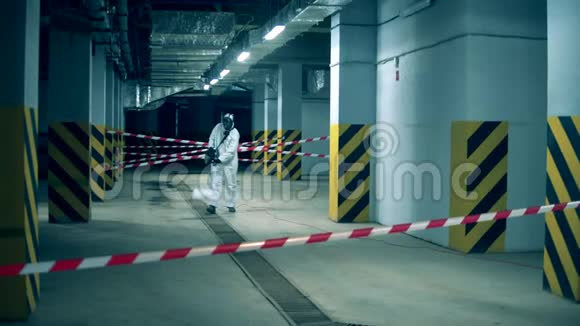 化学熏蒸的一个空的储存空间工人在室内使用化学品消毒预防冠状病毒视频的预览图