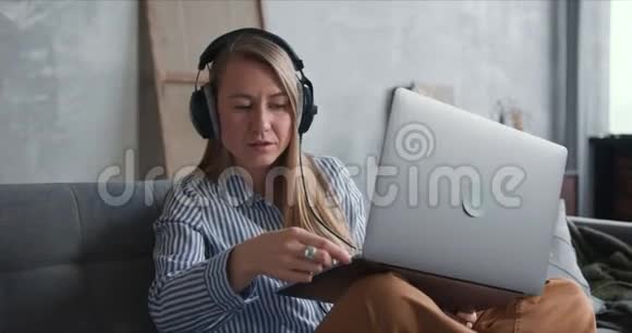 幸福健康的年轻医生女士在自我隔离期间使用笔记本电脑和耳机在家工作的肖像视频的预览图