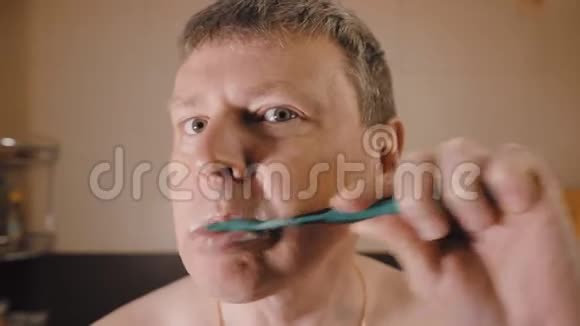 有趣的白人扭动着他的脸刷牙视频的预览图