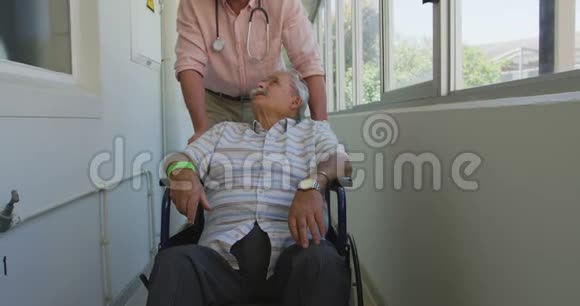 医生在养老院的走廊里和一位老人散步视频的预览图