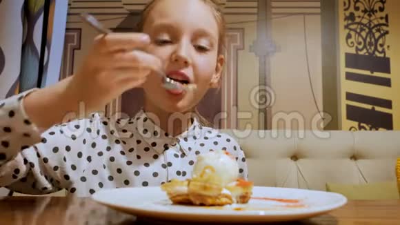 肖像欢快的少女在糖果咖啡馆里吃着甜甜点和冰淇淋快乐少女吃吃饭视频的预览图