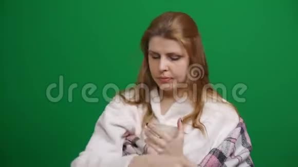 特写镜头生病的女人裹着温暖的毯子喝热茶咳嗽咳嗽喉咙痛COVID冠状病毒的危险视频的预览图