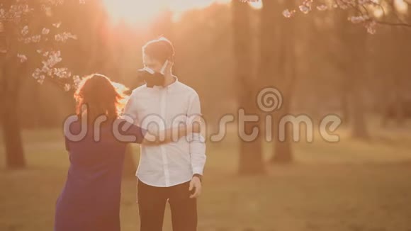 在利加樱花公园病毒流行期间快乐的一对夫妇在口罩上跳舞视频的预览图