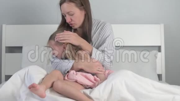妈妈在家里的床上安慰她哭泣的女儿视频的预览图
