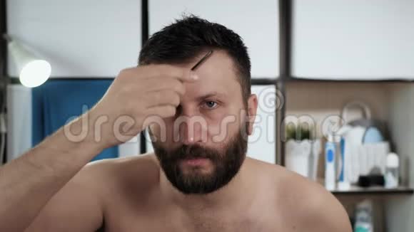 人在梳头年轻漂亮的白人在浴室里梳着镜子前的头发卫生视频的预览图