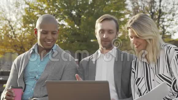 一群在公园里使用笔记本电脑的商人视频的预览图