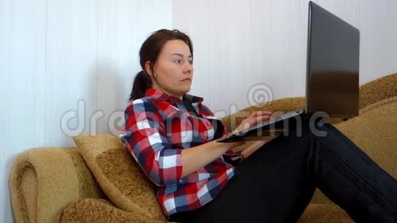 白人美女在笔记本电脑客厅的沙发上做自由职业者视频的预览图