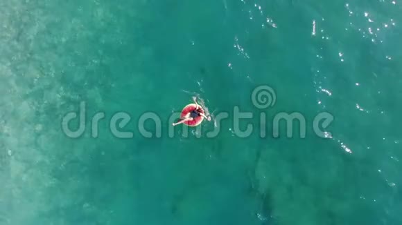 女孩漂浮在海上的橡胶圈上视频的预览图