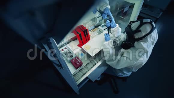 一个穿着防护服的人在实验室里与冠状病毒一起工作视频的预览图