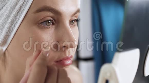 女孩染眉毛年轻貌美的女人头上戴着毛巾用特殊的铅笔画眉毛视频的预览图