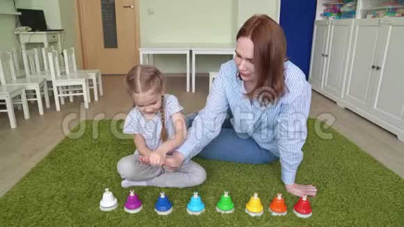 妈妈和女孩玩着五颜六色的音乐铃视频的预览图