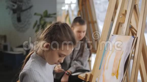 两个女孩在艺术学校用丙烯酸颜料描绘静物视频的预览图