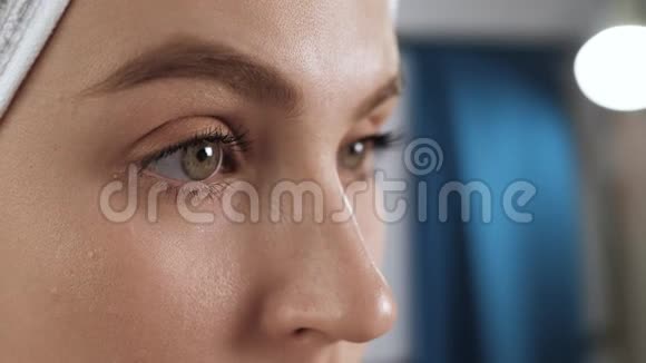 女孩用眉毛洗油漆浴室里的女人照镜子用棉垫把脸上的妆擦掉视频的预览图
