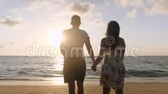 幸福夫妇沿着海滩漫步到海边冲浪视频的预览图