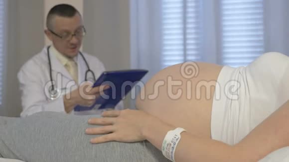 一名孕妇在诊所看妇科医生视频的预览图