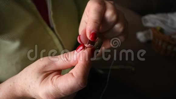 一个女人的特写镜头把线插入针中视频的预览图