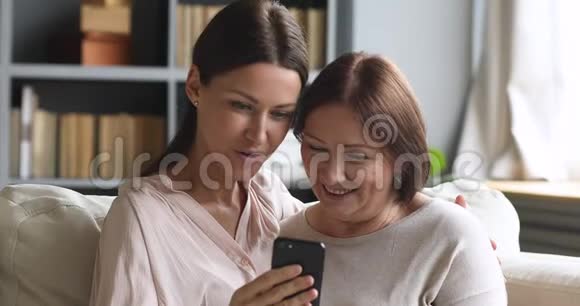 快乐成熟的母亲摆姿势自拍与成年女儿视频的预览图