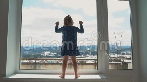 悲伤的孩子看着窗户无聊体贴的小女孩被隔离的人在家隔离病毒流行爆发视频的预览图