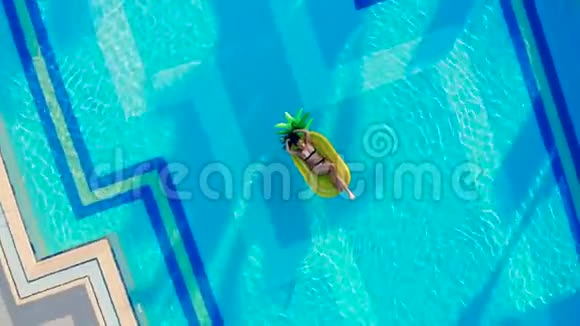年轻女子躺在游泳池里躺在橡胶圈上视频的预览图