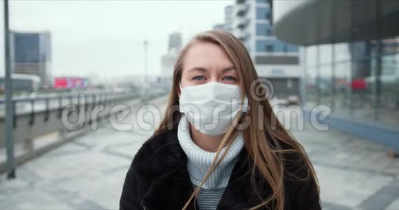 流行病保护欧洲年轻女性在户外戴着面具的肖像在检疫期间街道是空的视频的预览图