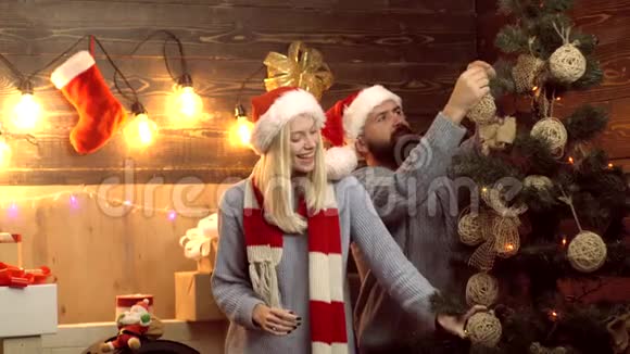 在家里相爱的圣诞夫妻圣诞装饰品幸福的夫妇装饰圣诞树主题圣诞视频的预览图