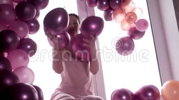 穿紫色裙子的女人坐在窗户上手里拿着气球视频的预览图