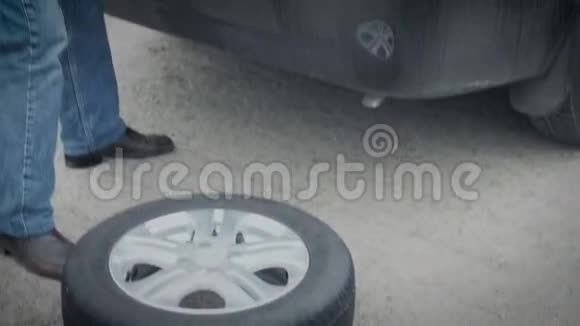 一个人从后备箱卸下汽车车轮用夏天代替冬天的轮胎视频的预览图