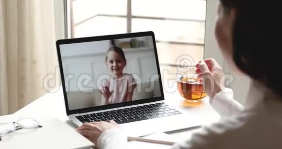 教师或母亲与小女孩交谈打视频电话视频的预览图