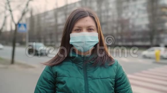 一个戴眼镜和戴医药面具的年轻女孩站在街上4k视频的预览图