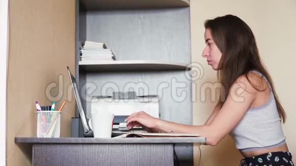年轻的白人女孩自由职业者在家里的笔记本电脑工作远程工作在键盘上打字在电脑里的女商人视频的预览图