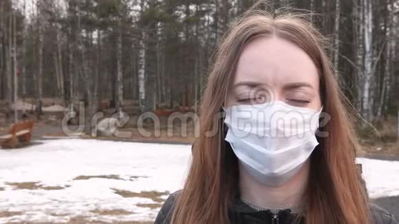 年轻女孩戴着医用口罩对病毒细菌和冠状病毒有健康保护在一个阴郁的前视频的预览图