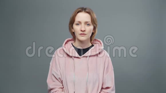 穿着粉红色运动衫的年轻体贴的女人视频的预览图