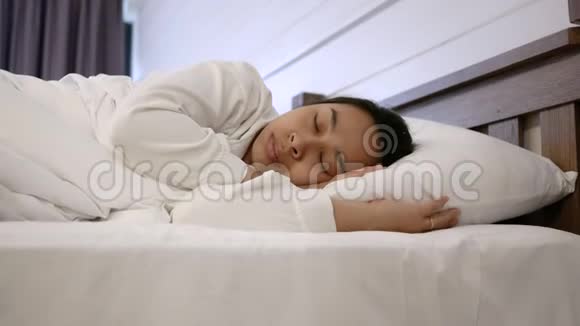 生病的女人被一条白色的毯子覆盖在床上咳嗽和高烧保健概念视频的预览图