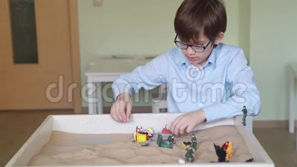 男孩眼镜是用光在桌子上的沙疗视频的预览图