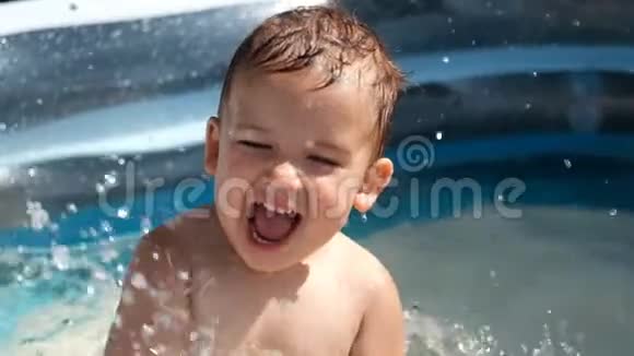 夏天一个白色的小孩子在游泳池里溅起水花视频的预览图