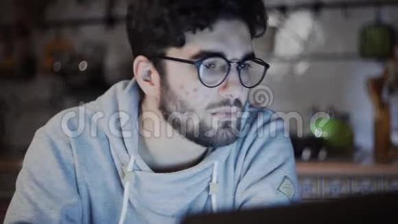 晚上在家厨房用笔记本电脑工作的自由职业者关门视频的预览图