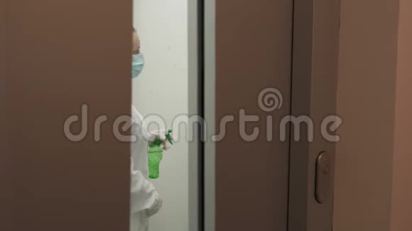 女士使用湿擦和酒精消毒喷雾清洁电梯按钮控制面板消毒视频的预览图