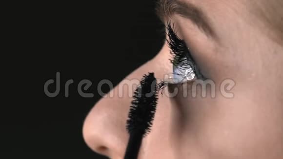 化妆师在美容工作室为年轻女性制作专业化妆的宏观镜头化妆师用睫毛膏视频的预览图