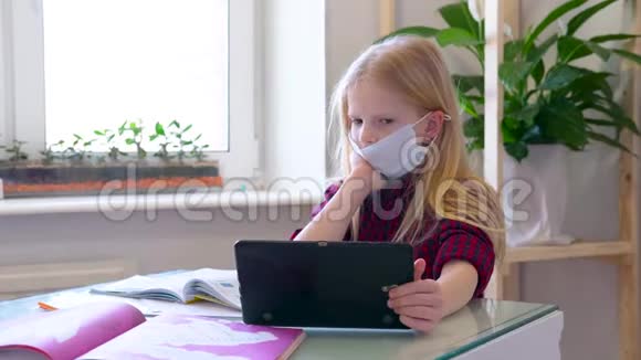 远程学习在线教育带着医用口罩在家学习的生病女学生手里拿着数码平板电脑视频的预览图