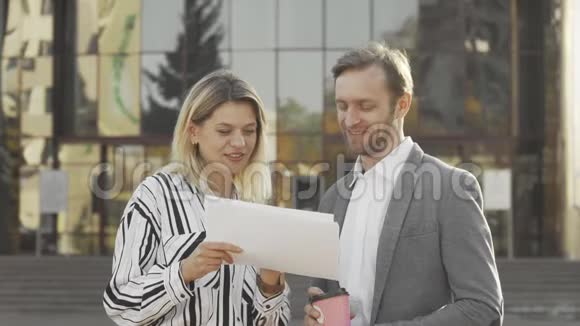 成熟的女商人和她的男同事在户外检查文件视频的预览图
