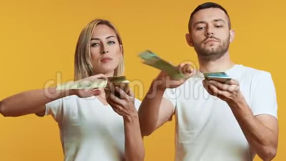 年轻夫妇扔钞票成功现金储蓄概念视频的预览图