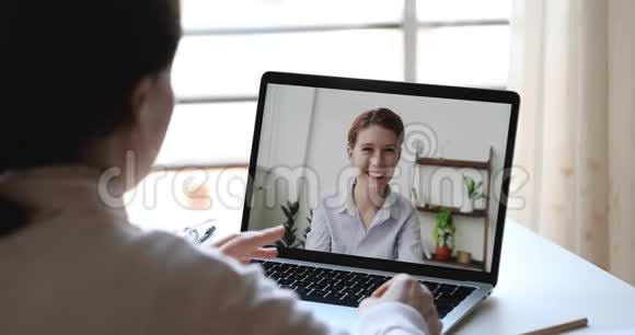 两个微笑的年轻商业女性朋友在视频通话视频的预览图