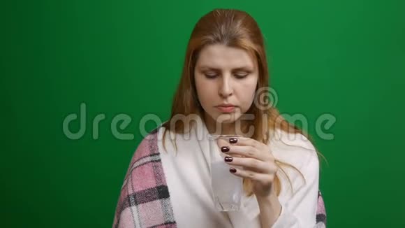 女人正在喝泡腾腾的药丸药丸滴下来用气泡溶解红头发COVID泡腾片视频的预览图