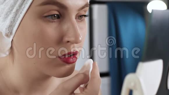 女孩洗妆浴室里漂亮的女人照镜子用棉垫擦口红化妆师化妆师视频的预览图