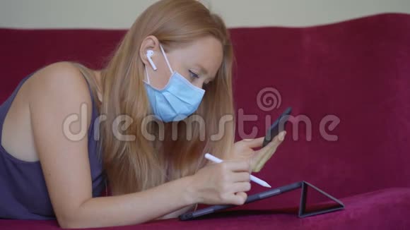 一位戴着医用面罩的年轻女子在冠状病毒自我隔离期间在家工作在视频的预览图