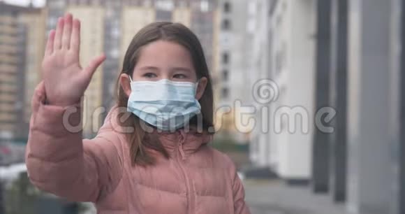 戴口罩的女孩表示停止使用手势来阻止电晕病毒的爆发视频的预览图
