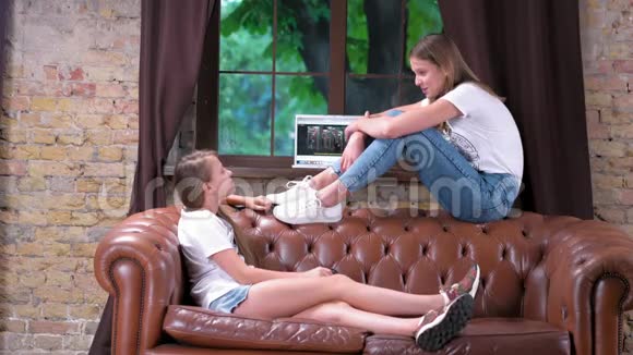 两个少女坐在沙发上互相交谈视频的预览图